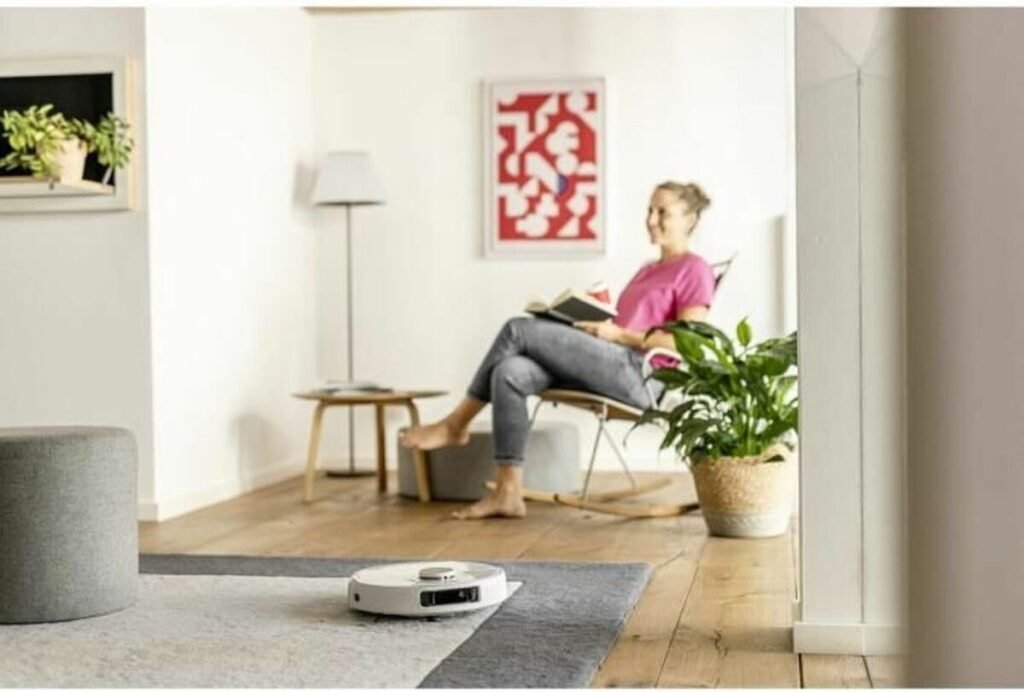 Kärcher RCV 5 : robot en fonctionnement dans un salon pendant que l'occupante lit (photo fabricant)
